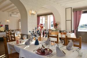 a dining room with a table with a white table cloth and chairs at Logis Hôtel Restaurant Berry Relais in Neuvy-Pailloux
