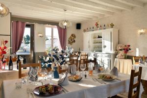 a dining room with a table with a white table cloth at Logis Hôtel Restaurant Berry Relais in Neuvy-Pailloux +16 photos