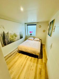 a bedroom with a bed and a window with pink flowers at Appartement moderne et chaleureux in Mutrécy