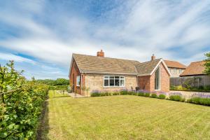 a brick house with a large yard at Deerwood in Grimston