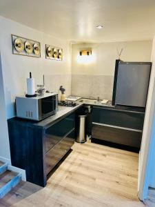 a kitchen with a counter top with a microwave at Appartement moderne et chaleureux in Mutrécy