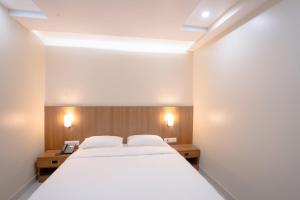 a bedroom with a large white bed and two night stands at Hotel Orchid Imphal in Imphal +28 photos