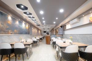 a dining room with tables and white chairs at Hotel Orchid Imphal in Imphal