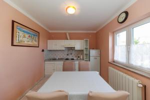 a kitchen with a white table and a clock on the wall at Villa Apolonija in Zadar