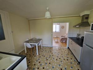 a kitchen with a table and a small table and a kitchen at Montignac, t2 proche Lascaux in Montignac +3 photos