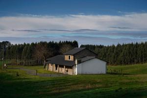 a white house in a field with trees at Casa Rural Lugar Vista Alegre in Lugo