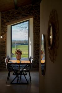 a table and chairs in a room with a large window at Casa Rural Lugar Vista Alegre in Lugo