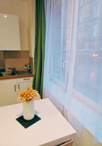 a vase of flowers sitting on a table next to a window at L'écrin médiéval in Fougères