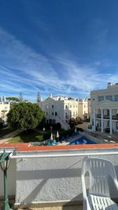 a balcony with a chair and a swimming pool at Old Village in Vilamoura