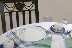 a table with a white plate on a table at Joyful Vista Guest Lodge in Victoria Falls