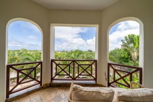a living room with three windows and a couch at Beat's Hideaway in Galu