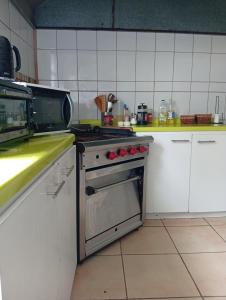 eine Küche mit Herd und Mikrowelle in der Unterkunft Hostel 566 in La Serena