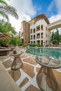 a building with a swimming pool and two tables at Beat's Hideaway in Galu