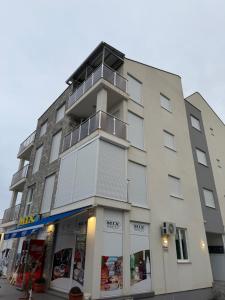 a tallartment building with a store in front of it at Zenith Apartment - Herceg Novi & Beach & Private Parking in Bijela
