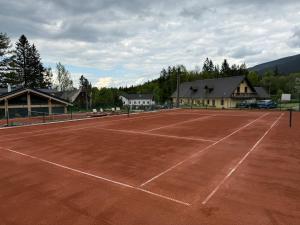 a tennis court in front of a building at Chata Ramzovské sedlo & Wellness in Ramzová