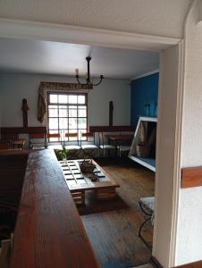 ein Wohnzimmer mit einem großen Holztisch und ein Zimmer mit einer Couch in der Unterkunft Hostel 566 in La Serena