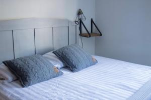 a bed with two pillows on top of it at Oes-Tilber in Zweeloo