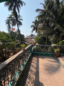 a balcony with a fence and palm trees at Virens Heaven Stays in Calangute