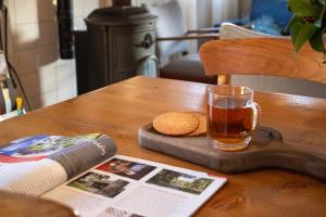 a book and a cup of tea on a wooden table at Oes-Tilber in Zweeloo +8 photos