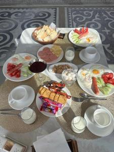 a table with plates of food on top of it at Argymak Hotel Karakol in Karakol +14 photos