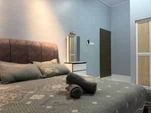a bedroom with a bed with a large headboard at Homestay De Acacia Rumah Melati in Kuala Terengganu