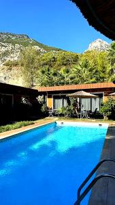 a large blue swimming pool in front of a house at Terra Garden Hotel in Kemer +16 photos