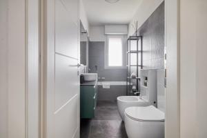 a bathroom with a white toilet and a sink at Assago Forum Apt - 3 min Walk in Assago