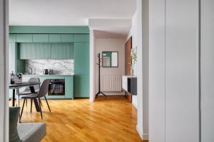 a kitchen and dining room with green cabinets and a table at Assago Forum Apt - 3 min Walk in Assago