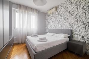 a bedroom with a large bed with a wall at Assago Forum Apt - 3 min Walk in Assago