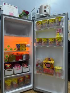 an open refrigerator filled with food and drinks at Homestay De Acacia Rumah Melati in Kuala Terengganu