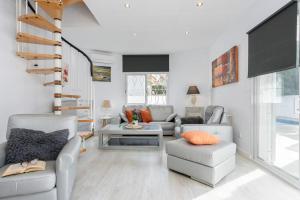 a living room with a couch and chairs and a tv at Piscina, mar y centro – Casa ideal para familias in Empuriabrava