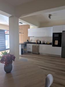 a kitchen with white cabinets and a vase of flowers at Vitoria's Vale in Funchal