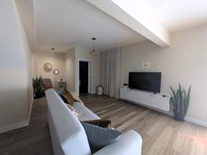 a living room with a couch and a flat screen tv at Vitoria's Vale in Funchal
