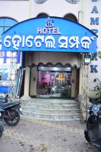 a hotel with a blue sign on the front of a building at Hotel Sampark in Bhadrak