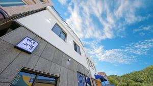 a building with a sign on the side of it at Yeosu Trip Pension in Yeosu