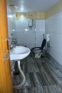 a bathroom with a sink and a toilet at Hotel Sampark in Bhadrak +22 photos