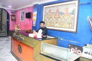 a man sitting at a counter in a room at Hotel Sampark in Bhadrak