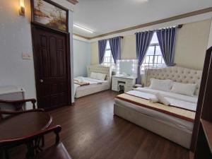 a bedroom with a large bed and a table at The Cloud Hotel in Da Lat