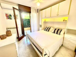 a bedroom with a bed in a room with a window at Grado Dolce Vita beachfront in Grado