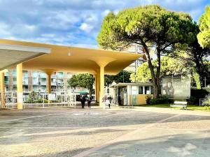 a building with a large yellow roof with people walking at Grado Dolce Vita beachfront in Grado
