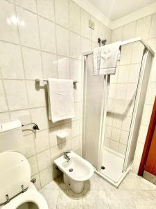 a white bathroom with a toilet and a shower at Grado Dolce Vita beachfront in Grado