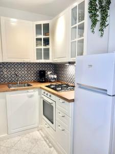 a kitchen with white cabinets and a white refrigerator at Grado Dolce Vita beachfront in Grado