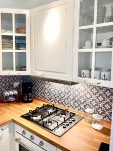 a kitchen with a stove and white cabinets at Grado Dolce Vita beachfront in Grado +10 photos