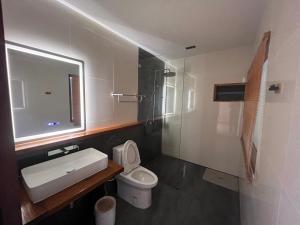 a bathroom with a toilet and a sink and a shower at บ้านซินอัน in Ban Rak Thai