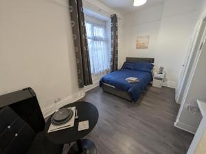 a small bedroom with a bed and a table at Tredegar Arms Budget Guesthouse For Walkers/Cyclists/Contractors/Traveler in Merthyr Tydfil