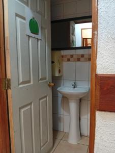 ein Badezimmer mit Waschbecken und weißer Tür in der Unterkunft Hostel 566 in La Serena + 46 Fotos
