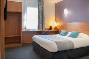 ein Hotelzimmer mit einem Bett und einem Fenster in der Unterkunft Brit Hotel Bressuire in Bressuire