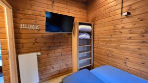 a room with a tv in a wooden wall at Das Haus Kaninchenhöhle in Dankern