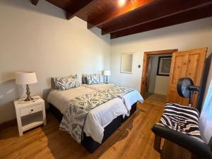 a bedroom with a bed and a chair in it at Windkraal Farm House in Bonnievale