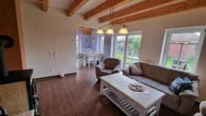 a living room with a couch and a table at Ferienhaus Sommerwind in Neßmersiel +26 photos
